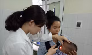 Bác sĩ Vũ Quế Anh đang xem xét tình trạng hoại tử của bé Kiên trước khi phẫu thuật cắt bỏ hoàn toàn. Ảnh: Đinh Tuấn.