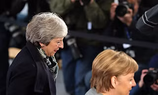 Thủ tướng Anh Theresa May (trái) và Thủ tướng Đức Angela Merkel trong một sự kiện ngày 11/12. Ảnh: Bloomberg
