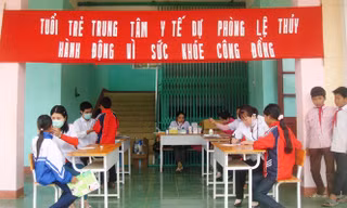 Nhân viên y tế tại Trung tâm y tế huyện Lệ Thủy khám bệnh cho học sinh ảnh: PV