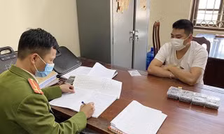 Đối tượng Hoàng Văn Tùng (bìa phải) khai nhận hành vi sản xuất đạn tại cơ quan công an -Ảnh: TL