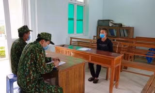 Đối tượng Tấm (bìa phải) khai nhận hành vi phạm pháp với lực lượng Biên phòng .Ảnh: Vi Toàn 