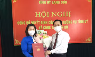 Đồng chí Hoàng Văn Nghiệm, Phó Bí thư TT tỉnh ủy Lạng Sơn (phải) trao Quyết định, tặng hoa chúc mừng chị Lê Thùy Dung (trái). - Ảnh: Duy Chiến 