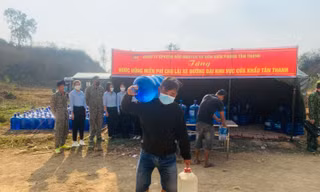 Lái xe chở nông sản vui mừng được phát bình nước sạch miễn phí -Ảnh: Duy Chiến 