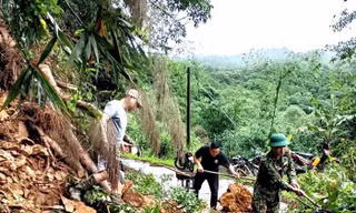 Các ngành chức năng, cán bộ chiến sỹ và nhân dân huyện Tràng Định phối hợp dọn dẹp cây cối, đất đá sạt lở xuống đường tuần tra biên giới -Ảnh: Đ.Q