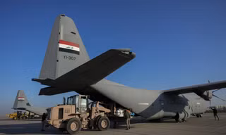 Lực lượng an ninh Iraq dỡ hàng viện trợ nhân đạo tại sân bay quân sự gần Baghdad ngày 24/1. (Ảnh: AP)