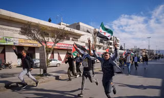 Người Syria ở thị trấn Bar Elias của Li-băng ăn mừng sự sụp đổ của chính phủ Bashar al-Assad ngày 8/12. (Ảnh: AP)