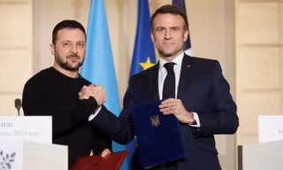 Tổng thống Pháp Emmanuel Macron và người đồng cấp Ukraine Volodymir Zelensky khi ký thỏa thuận an ninh tại Paris. (Ảnh: Reuters)