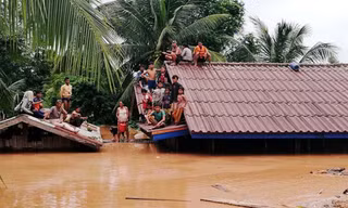 Người dân ở tỉnh Attapeu phải tạm trú trên mái nhà do ngập lụt ngày 24/7. Ảnh: Reuters. 