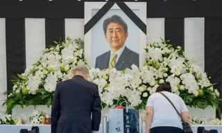 Người dân cúi đầu trước di ảnh cố Thủ tướng Abe Shinzo bên ngoài nhà thi đấu Nippon Budokan ở Tokyo. (Ảnh: Reuters)