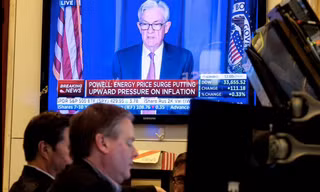Hình ảnh chủ tịch Fed Jerome Powell được phát trên màn hình tại sàn chứng khoán New York khi thông báo về việc tăng lãi suất. (Ảnh: Reuters)