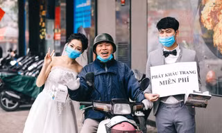 Chú rể Nghiêm Đình Đăng và cô dâu Phạm Ngọc Vy tặng khẩu trang miễn phí cho người dân Hà Nội. ảnh: Windy Wedding.