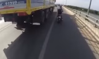Cô gái liều mạng “nấp hông” theo xe tải để tránh nắng