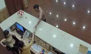 Đối tượng nhận chìa khóa phòng từ bàn lễ tân của khách sạn. Ảnh chụp lại camera.