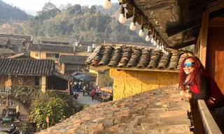 Du khách thích thú khi chụp ảnh với nhà trình tường tại Lô Lô Chải (xã Lũng Cú, huyện Đồng Văn). Ảnh: Nguyễn Việt Dũng