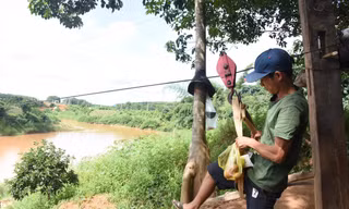 Người dân liều mình đu qua sông trên sợi dây cáp 