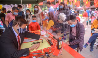 Ông đồ đeo khẩu trang, cho chữ qua tấm chắn ngày đầu năm mới