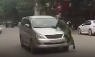Lái xe bất chấp trên nắm ca pô có người vẫn nổ máy bỏ chạy - Ảnh: Cắt từ clip