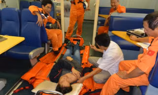 Lực lượng cứu nạn của Trung tâm II cùng nhân viên y tế chăm sóc sức khỏe cho một ngư dân gặp nạn trên biển. 