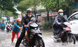 Một gia đình TP HCM đưa con đi học trong cơn mưa ở TP HCM. Ảnh minh họa: Mạnh Tùng.