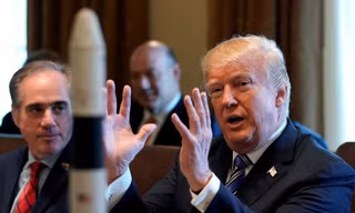 Ông Trump trò chuyện tại Nhà Trắng với mô hình tàu vũ trụ đặt trên bàn. Ảnh: Reuters
