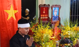 Anh Trần Minh Hùng, em trai liệt sĩ Trần Quang Khải đứng bên bàn thờ anh trai tại nhà riêng. Ản