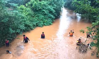 Lực lượng cứu hộ sử dụng lưới để tìm kiếm cháu bé bị nước cuốn
