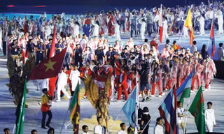 Tình nguyện viên nước chủ nhà rước quốc kỳ Việt Nam tiến vào sân VĐV Bung Karno trong lễ bế mạc Asiad 2018