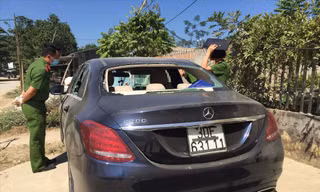 Chiếc xe sang để bên đường, kính sau và các cửa kính đều bị đập vỡ, trong xe có dấu vết máu