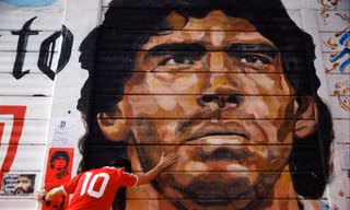 Người hâm mộ gục khóc bên bức​tranh Maradona bên ngoài SVÐ​Argentinos Juniors 
