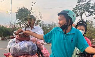 Người chở hàng ở chợ đầu mối Bình Điền vui mừng mua được chậu mai giá rẻ về đón Tết. Ảnh: U.P