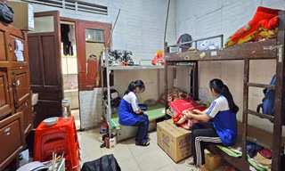 Các em học sinh ở trong khu ký túc xá chật chội, quần áo giăng kín lối đi