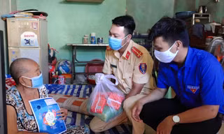 Các chiến sĩ CSGT tặng quà cho người nghèo.