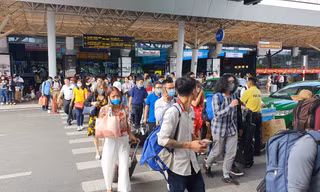 Hành khách đi bộ cắt ngang các làn ô tô trước ga quốc nội.