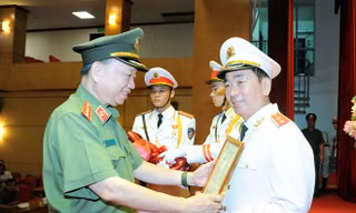 Bộ trưởng Tô Lâm trao Quyết định của Chủ tịch nước thăng cấp bậc hàm từ Thiếu tướng lên Trung tướng cho Thứ trưởng Trần Quốc Tỏ. (ảnh: mps)