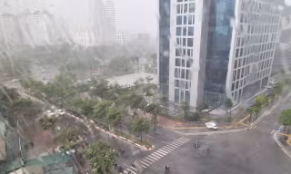 Mưa to gió lớn khiến người đi xe máy không thể di chuyển ở đoạn đường gần khu Đại sứ quán Mỹ thuê