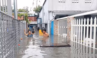 TPHCM: Mưa lớn đầu mùa, người dân 'chạy ngập'