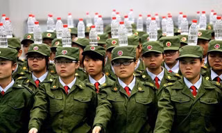 Các sinh viên của trường Học viện Quản lý Công nghiệp Hàng không Trịnh Châu phải đội chai nước khi tập quân sự.