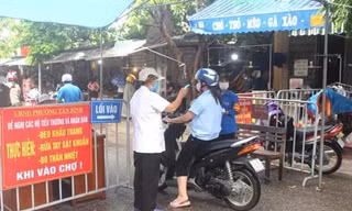 Đo nhiệt độ người dân trước khi họ vào chợ tại Hải DươngNguồn: QĐND
