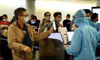 Nhân viên kiểm dịch kiểm tra khai báo y tế, hộ chiếu người nhập cảnh tại sân bay Tân Sơn Nhất - ảnh: Ngô Bình, mạnh thắng