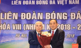 Cựu Chủ tịch VFF Lê Hùng Dũng (trái) tặng hoa chúc mừng tân Chủ tịch Lê Khánh Hải 