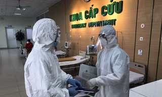 Điều dưỡng Trường (phải) đang trao đổi với đồng nghiệp về bệnh nhân nghi nhiễm