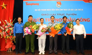 Tổng biên tập báo Tiền Phong Lê Xuân Sơn (bên phải) và Quyền Trưởng ban Tuyên giáo Trung ương Đoàn Lê Quang Tự Do (bên trái) tặng hoa các vị khách mời. Ảnh: Xuân Tùng