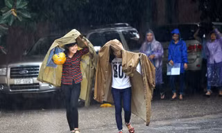 Thí sinh đội mưa đến trường thi
