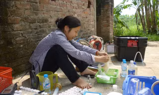 Một nghiên cứu viên (Đại học Quốc gia Hà Nội) đang lấy mẫu kiểm tra nước ngầm nhiễm arsenic tại Xã Vạn Phúc. (Ảnh do thành viên đoàn nghiên cứu cung cấp).
