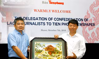Phó Tổng Biên tập báo Tiền Phong Trần Thanh Lâm tặng quà lưu niệm đoàn đại biểu nhà báo Lào.