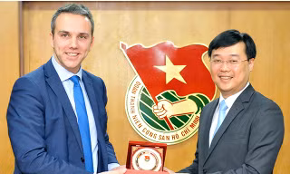 Anh Lê Quốc Phong (bên phải) – Ủy viên dự khuyết BCH T.Ư Đảng, Bí thư T.Ư Đoàn tặng logo huy hiệu Đoàn TNCS Hồ Chí Minh cho ông Vandenkendelaere 