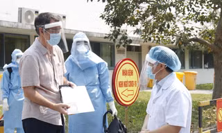 Giám đốc Bệnh viện Trung ương Huế Phạm Như Hiệp (bìa phải) chúc mừng bệnh nhân thứ 33 được chữa khỏi Covid-19 và dặn dò người này tiếp tục theo dõi sức khỏe theo quy định.