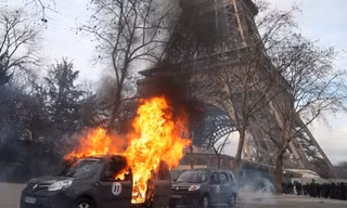 Xe quân sự chống khủng bố bị người biểu tình đốt gần Tháp Eiffel hôm 9/2. Ảnh: AFP