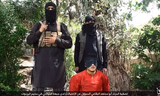 Abu Mujahid al-Baqai trong bộ trang phục màu cam quỳ gối trước hai chiến binh IS