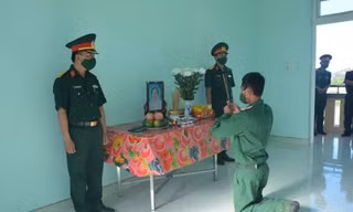 Binh nhì Nguyễn Huy Hoàng vọng bái mẹ trước bàn thờ được lập trong đơn vị. (Ảnh: B.N)